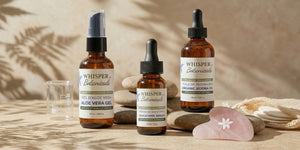 Collection of 'Whisper of Botanicals' skincare products on a wooden surface with a natural background.